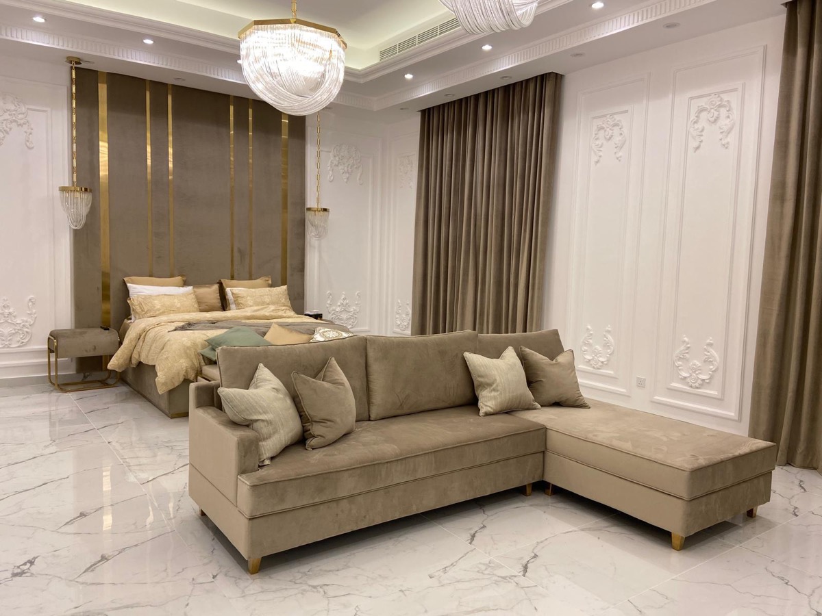 Before: A bedroom suite, recomposed into a clean wide shot built around the brass and velvet headboard wall.
